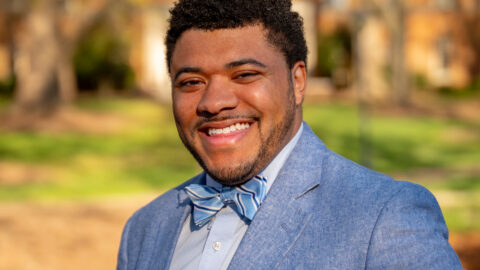 A person in a Carolina blue suit and bow tie poses for a photo.