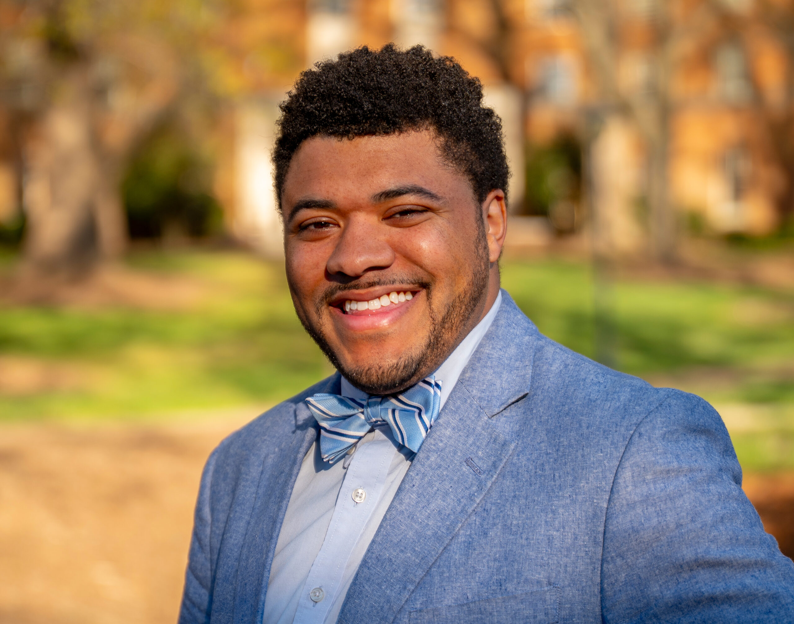 A person in a Carolina blue suit and bow tie poses for a photo.